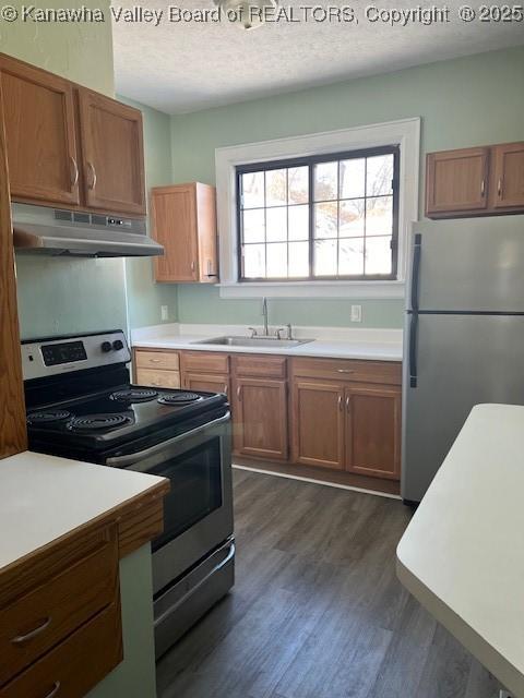 kitchen featuring sink, dark wood-type flooring, appliances with stainless steel finishes, and a textured ceiling