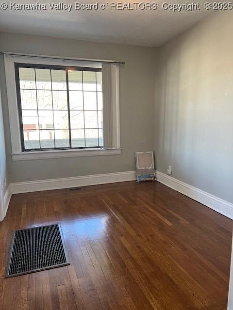 unfurnished room with a wealth of natural light and dark hardwood / wood-style flooring