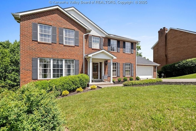 colonial inspired home with a garage and a front yard