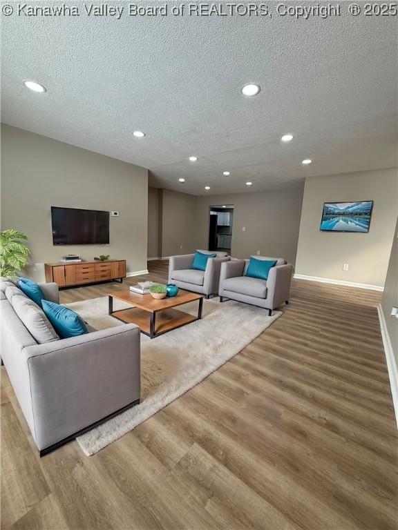 living room with wood-type flooring and a textured ceiling