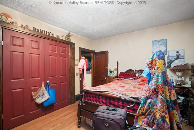 bedroom with hardwood / wood-style floors, a closet, and a textured ceiling