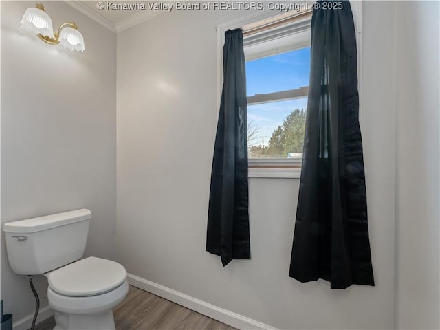 bathroom with crown molding, wood-type flooring, and toilet