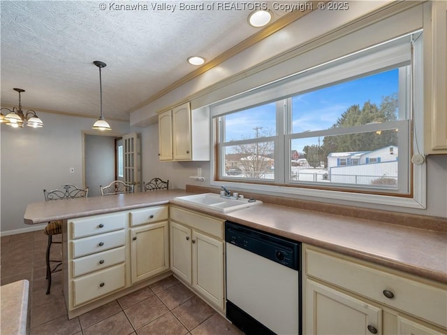 kitchen featuring sink, hanging light fixtures, white dishwasher, cream cabinets, and kitchen peninsula