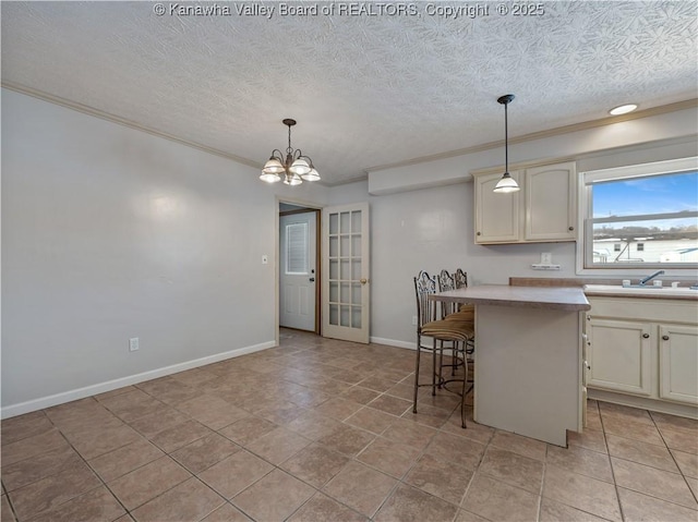 kitchen with crown molding, sink, decorative light fixtures, and a kitchen bar