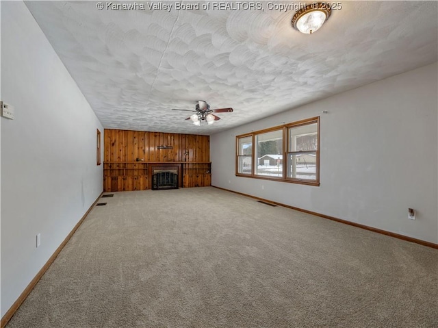 unfurnished living room with ceiling fan, carpet floors, and a textured ceiling