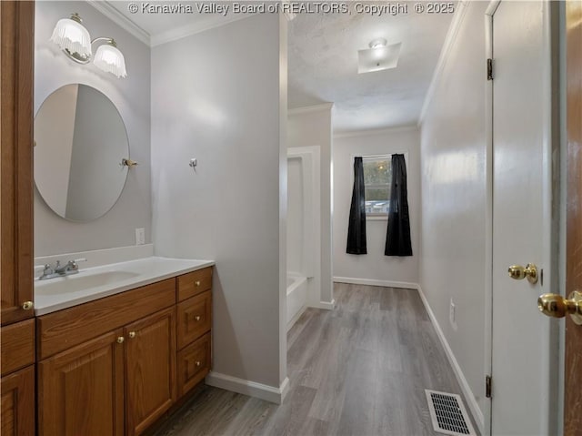 bathroom featuring vanity, hardwood / wood-style floors, ornamental molding, and shower / bathtub combination