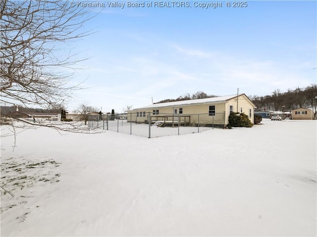 view of snow covered rear of property