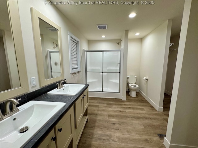 bathroom with vanity, wood-type flooring, toilet, and walk in shower