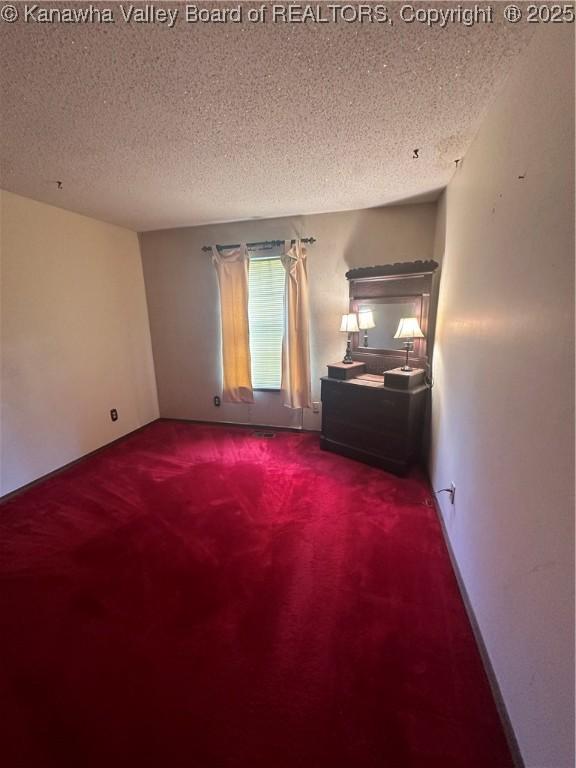 carpeted empty room with a textured ceiling