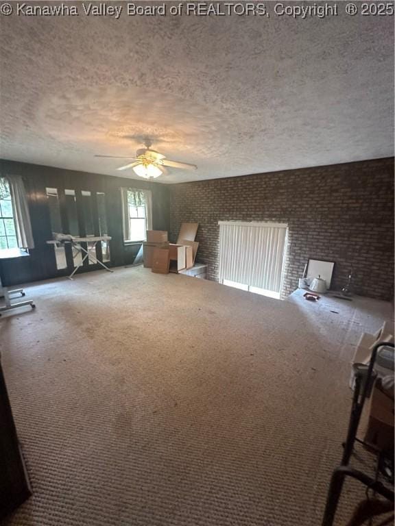 interior space featuring ceiling fan, carpet floors, and a textured ceiling