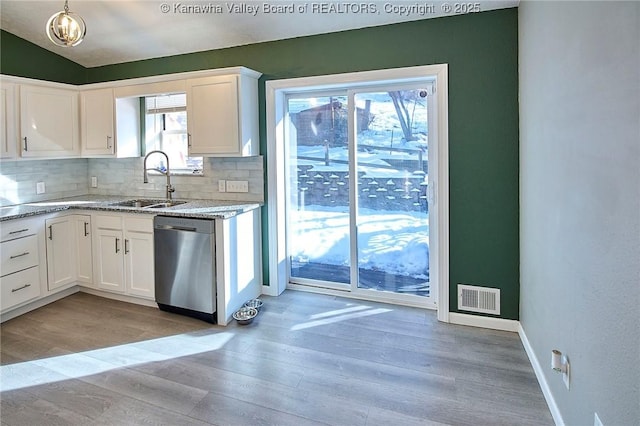 kitchen with sink, stainless steel dishwasher, white cabinets, and light hardwood / wood-style flooring