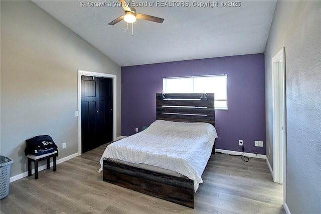 bedroom featuring hardwood / wood-style flooring, lofted ceiling, and ceiling fan