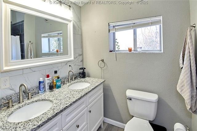 bathroom with vanity, decorative backsplash, plenty of natural light, and toilet