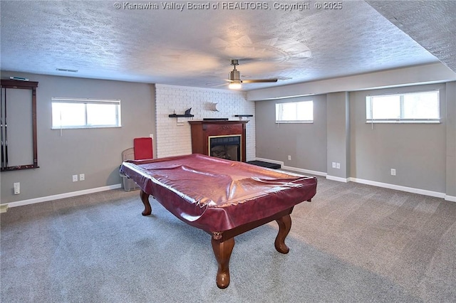 rec room featuring a large fireplace, a textured ceiling, carpet, and a wealth of natural light