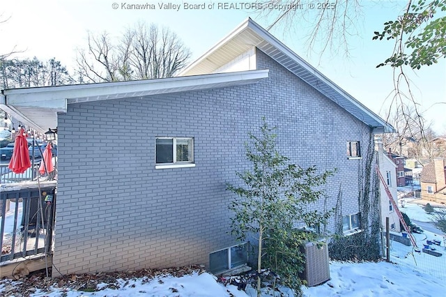 view of snowy exterior featuring central AC