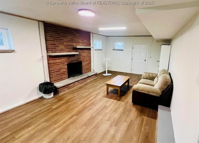 living room featuring light hardwood / wood-style floors and a brick fireplace