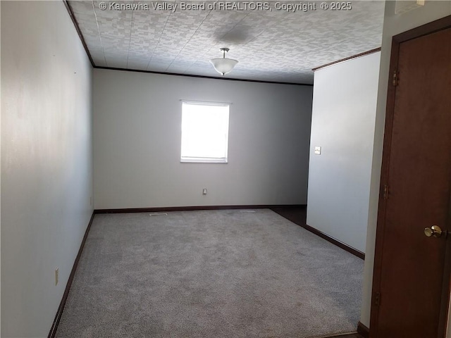 empty room featuring ornamental molding and carpet