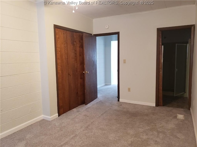 unfurnished bedroom featuring light carpet, crown molding, and a closet