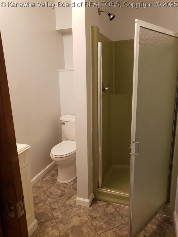 bathroom featuring vanity, toilet, and a shower with door