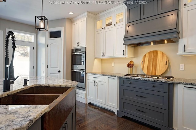 kitchen featuring sink, white cabinets, dark hardwood / wood-style flooring, light stone counters, and stainless steel appliances