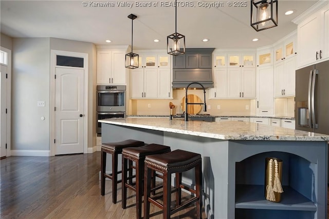 kitchen featuring pendant lighting, white cabinetry, stainless steel appliances, and a large island