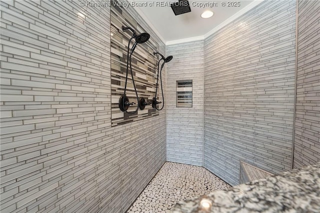 bathroom featuring a tile shower and crown molding