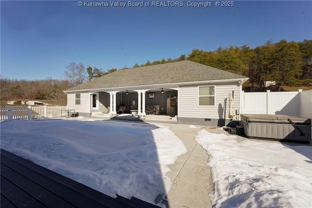 rear view of property featuring a hot tub