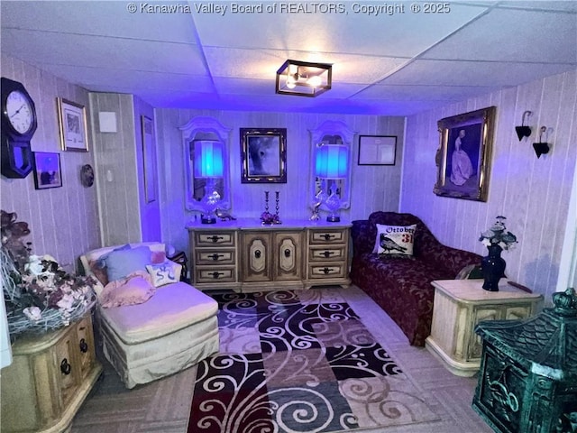 bedroom with a drop ceiling and wood walls