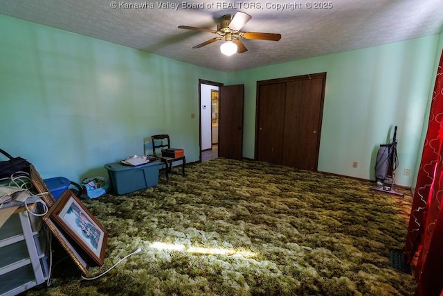 carpeted bedroom with ceiling fan, a closet, and a textured ceiling