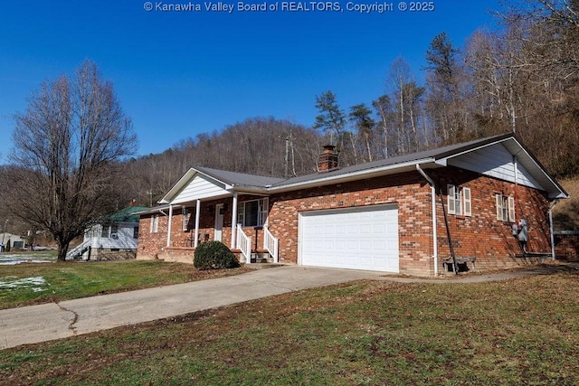 single story home featuring a garage, a porch, and a front yard