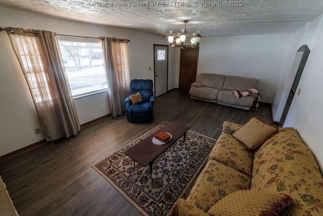 living room with a chandelier, dark hardwood / wood-style floors, and a textured ceiling