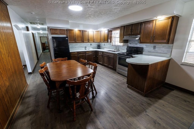 kitchen with black fridge, stainless steel range with electric stovetop, sink, and backsplash