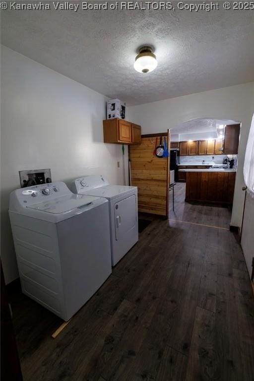 washroom with washer and dryer, a textured ceiling, and dark hardwood / wood-style flooring