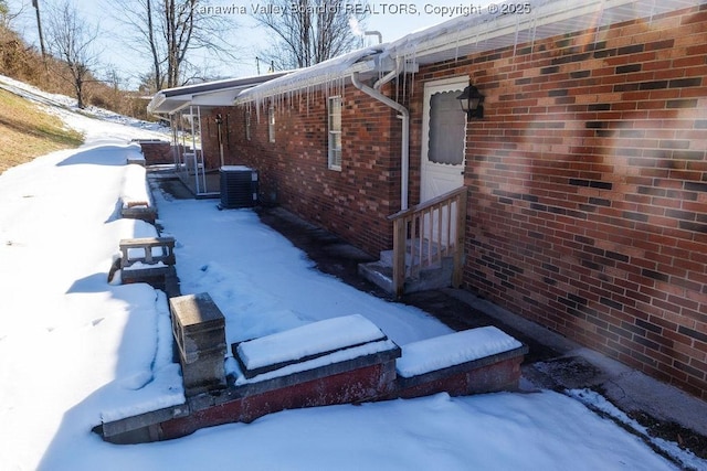 view of snowy exterior featuring cooling unit