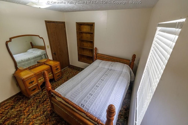 bedroom with a closet, a textured ceiling, and carpet