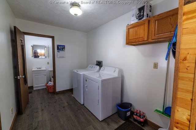 laundry area featuring cabinets, washing machine and dryer, dark hardwood / wood-style floors, and a textured ceiling