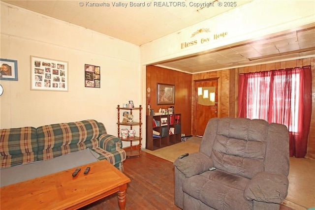 living room featuring dark wood-type flooring and wood walls