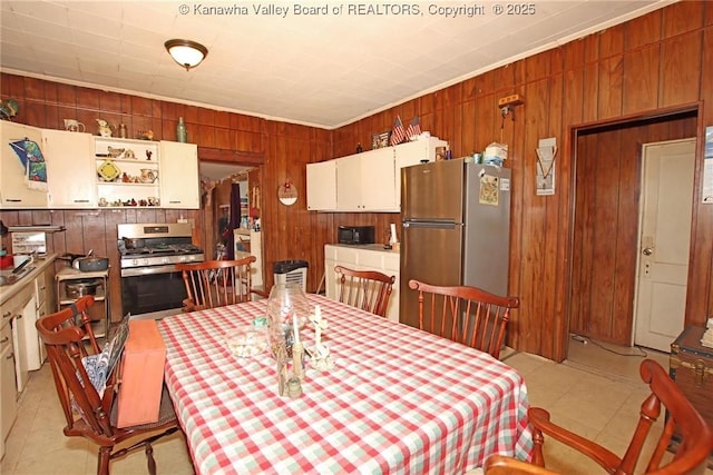 dining room featuring crown molding and wood walls