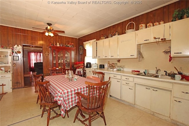 kitchen with sink, crown molding, and wooden walls