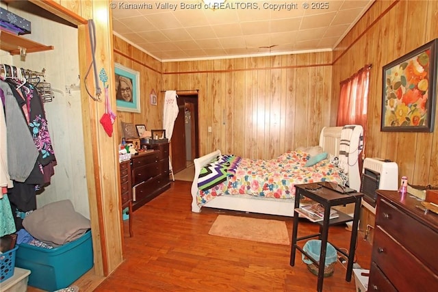 bedroom featuring heating unit and hardwood / wood-style floors