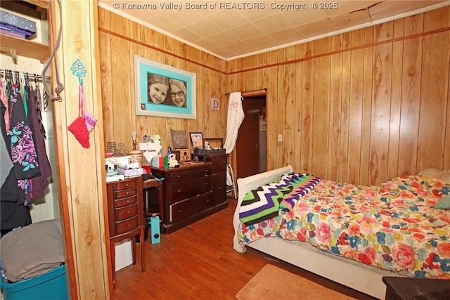 bedroom with wooden walls and hardwood / wood-style floors