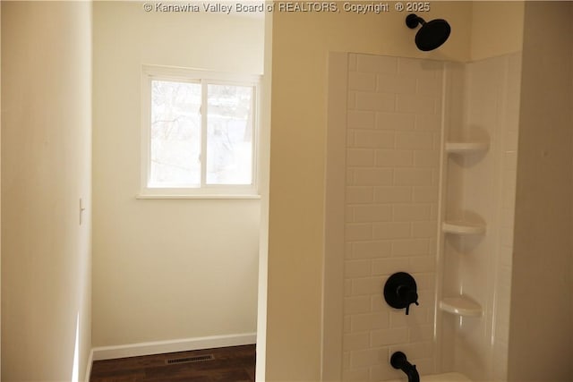 bathroom featuring hardwood / wood-style flooring and  shower combination