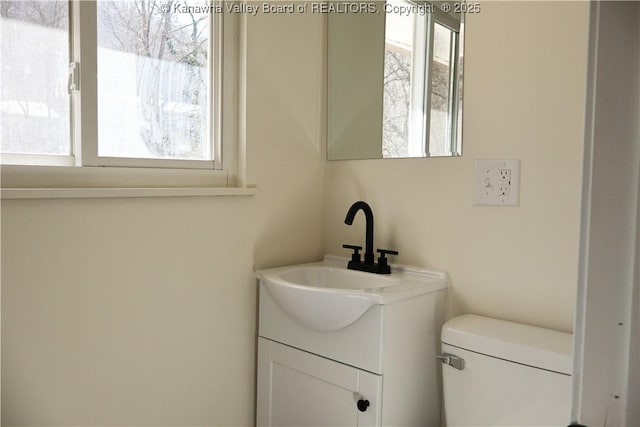 bathroom featuring vanity, plenty of natural light, and toilet