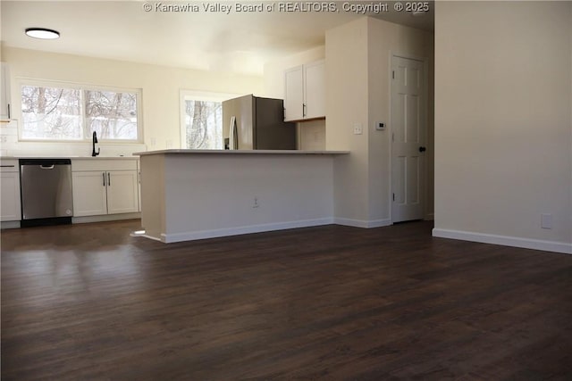 kitchen with stainless steel appliances, sink, white cabinets, and dark hardwood / wood-style floors