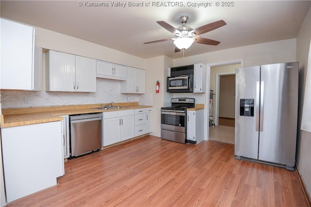 kitchen featuring stainless steel appliances, sink, and white cabinets