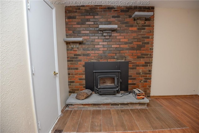 interior details with hardwood / wood-style flooring and a wood stove