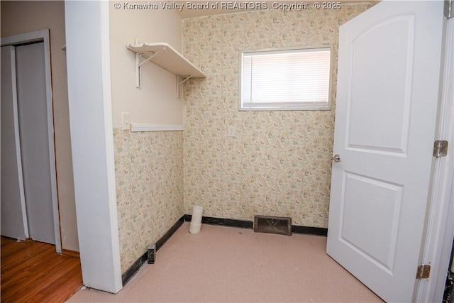 clothes washing area with wood-type flooring