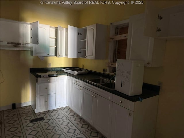 kitchen featuring white cabinetry and sink