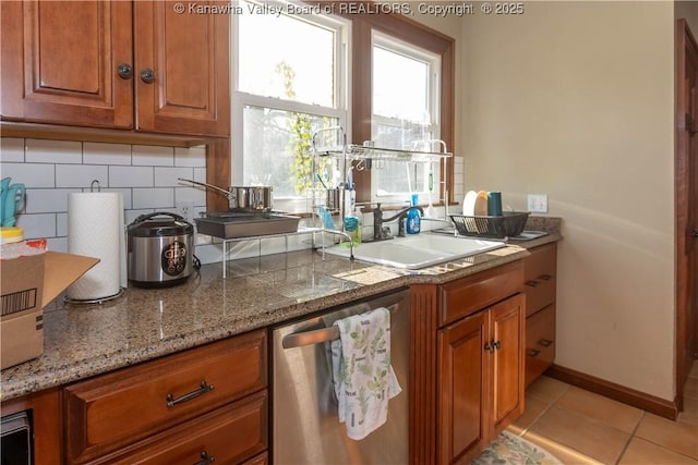 kitchen featuring sink, decorative backsplash, stainless steel dishwasher, light tile patterned floors, and light stone countertops