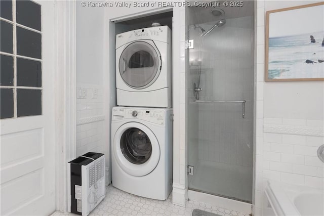 laundry room featuring stacked washer and dryer and light tile patterned flooring